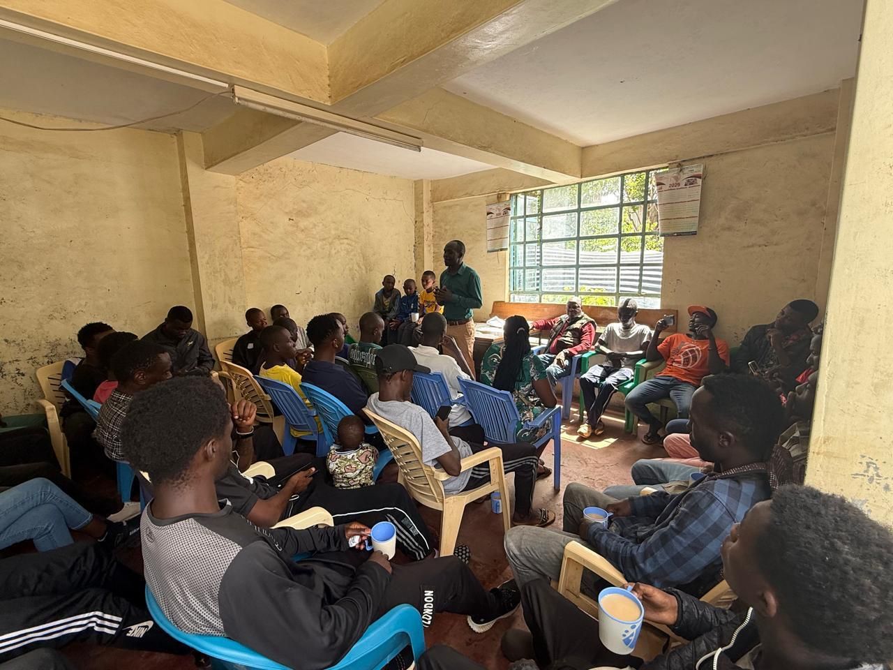 A packed hall of young men listening