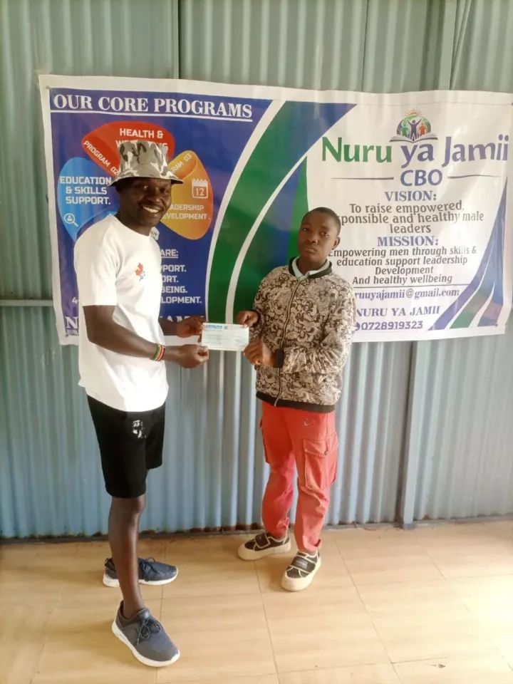 Presenting a school fees cheque to a student